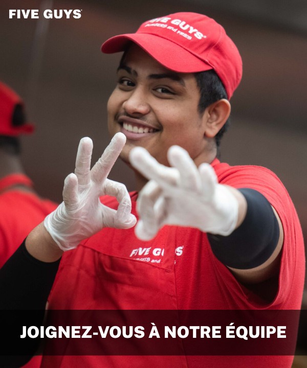 Un employé de Five Guys pose pour une photo alors qu'il travaille dans la cuisine.